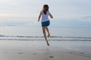 Fototapeta na wymiar woman jumping at seaside