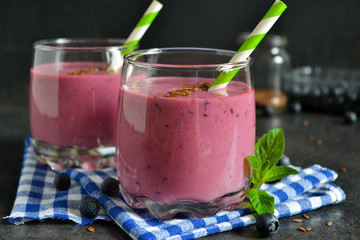 berry smoothie with blueberries, oats and flax seeds on a black