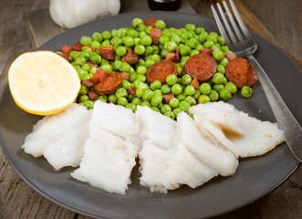 plate of grilled fish and cooked with ham and chorizo peas in ol