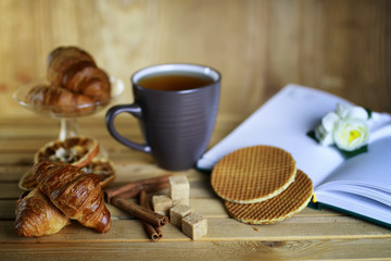 cup with tea croissant book