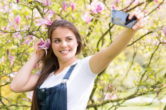 junge frau fotografiert mit dem mobiltelefon ein selfie