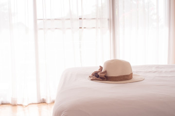Straw hat on the white bed