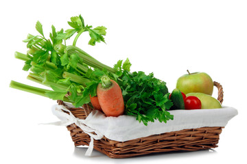 Fresh green celery with other vegetables in a wicker basket on white isolated background