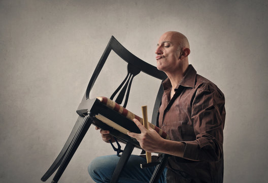 Man Fixing A Wooden Chair