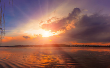 Fototapeta na wymiar Colorful sunset majestic lake. sunlight breaks through the clouds. dramatic scene. color in nature