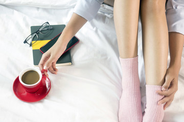 Fototapeta na wymiar Beautiful woman is drinking coffee on bed, in the morning.