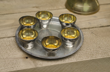 set of silver cups on a tray