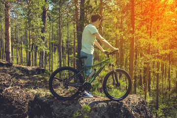 Plakat biker with bike on the rocks. Sport, adventure, motivation.