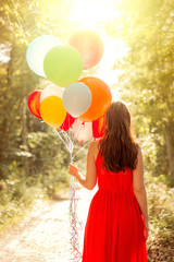 A woman holding a bunch of balloons © detailblick-foto