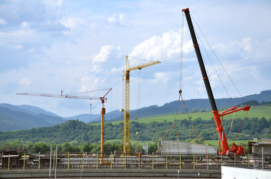 Three high working cranes on highway construction site