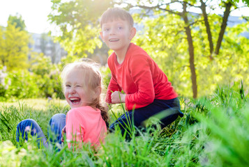 Naklejka na ściany i meble Two happy laughing kids playing in a garden