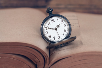 Vintage pocket watch on old books.