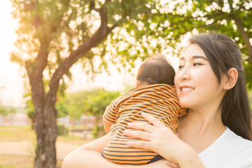 Naklejka premium asian 2 months baby feeling happy and smiles with her mother in
