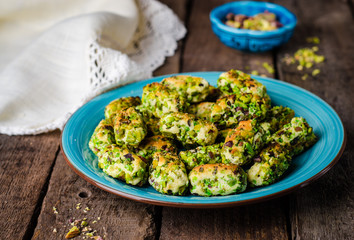 Maamoul - arabic cookies with pistachio in metal bowl on vintage wooden table background. Selective focus