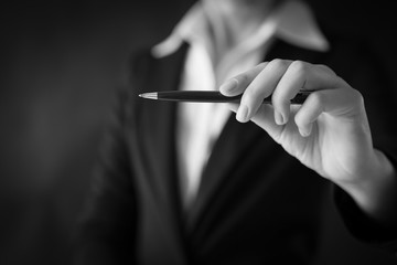 Hand holding pen, black and white business theme background