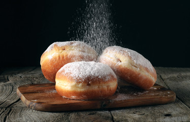 Three donut sprinkled with powdered sugar