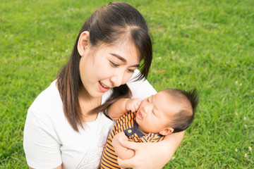 asian 2 months baby feeling happy and smiles with her mother in