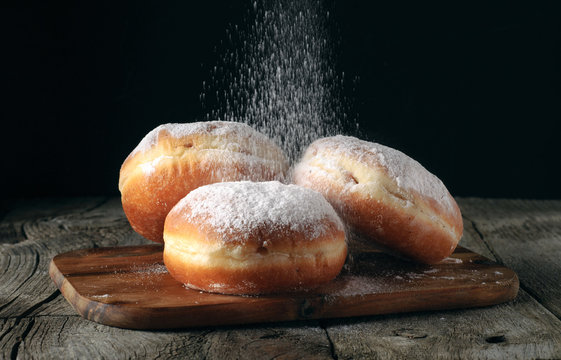 Three donut sprinkled with powdered sugar