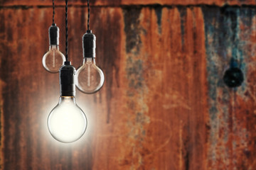 Idea and leadership concept -  bulbs on the grunge background