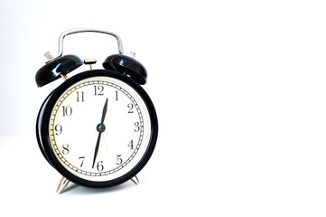 Retro alarm clock with retro colored in white background, white background with retro alarm clock on table, Big old vintage alarm clock with bells, painted white wooden background