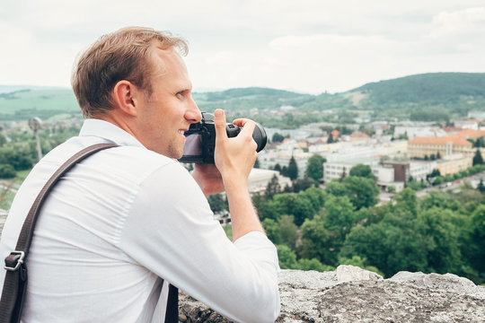 Man with professional photo camera take landscape picture