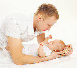 Father with his baby lying on bed at home