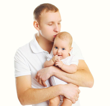 Loving father hugging and kissing baby on white background