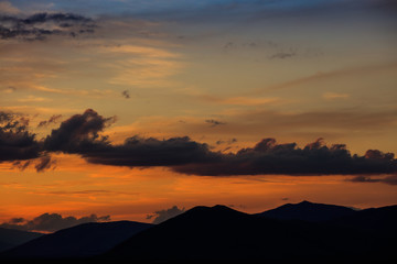 Fototapeta na wymiar Idyllic scene of mountains silhouette under evening sky