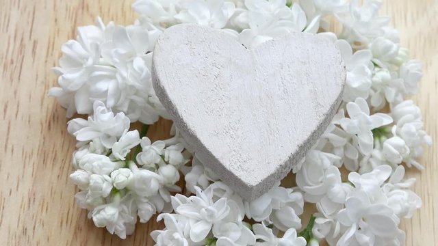 heart  and white lilac rotate on wood