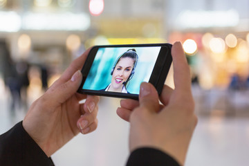 woman hand holding a smartphone during a skype session