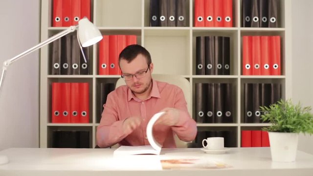 Man In Office Reading Technical Book
