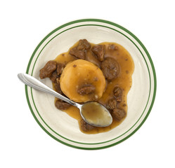 Mashed potatoes gravy and beef tips TV dinner with spoon