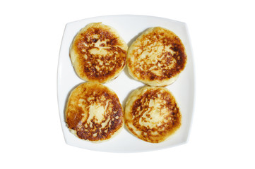 Pancakes on a white plate on a white background. Fried pancakes on a plate top view. Pancakes for Breakfast on a square plate. A healthy Breakfast of pancakes on a plate.