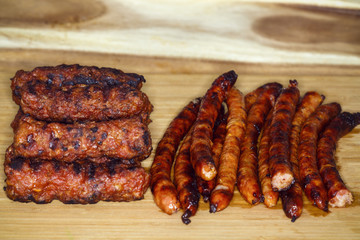 Grilled sausage and meatball on a wooden board