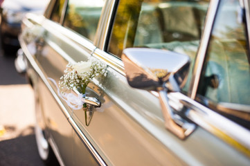 Zabytkowy samochód do ślubu udekorowany kwiatami i wstążkami