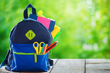 Full School backpack on wooden and nature background