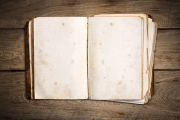 Open blank book on wood background.