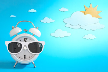 Alarm clock wearing sunglasses on day sky paper craft., Daytime concept.