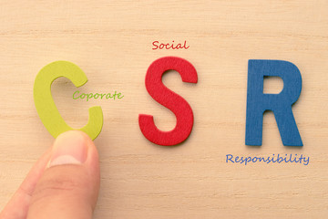 Hand arrange letters as CSR (Coporate , Social , Responsibility)