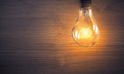 Fototapeta na wymiar Light bulb on wooden surface