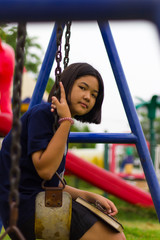 Fototapeta na wymiar Teen girl swings Playground.