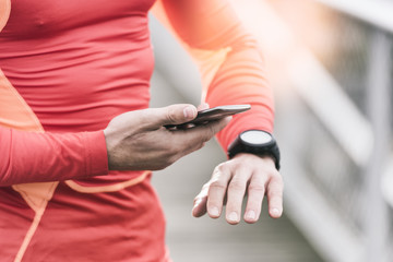 Obraz na płótnie Canvas Running man checking sport performance on his mobile phone