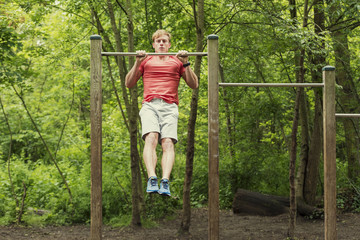 Male athlete doing muscle-up on horizontal bar