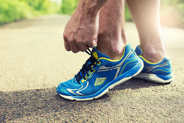 Runner tying his running shoes. Road forest man shoelace sneaker