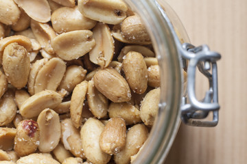 Open canning jar with fried salty peanuts. Overhead view