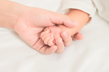 selective focus hand the sleeping baby in the hand of mother clo