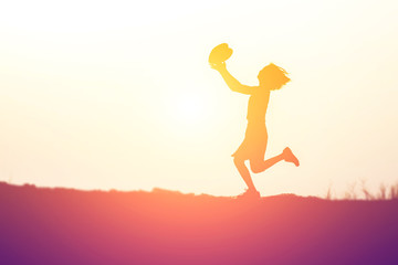 Fototapeta premium a silhouette of a happy young girl child in hands give heart th