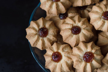 Plate with buscuit cookes with jam on black background