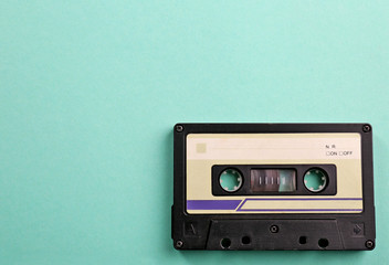 Old audio cassette on turquoise background