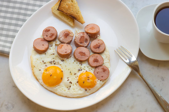 Hearty breakfast of eggs, sausage and toasts.